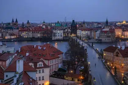 Distant city rooftops and a courthouse exterior at dusk with anonymous silhouettes