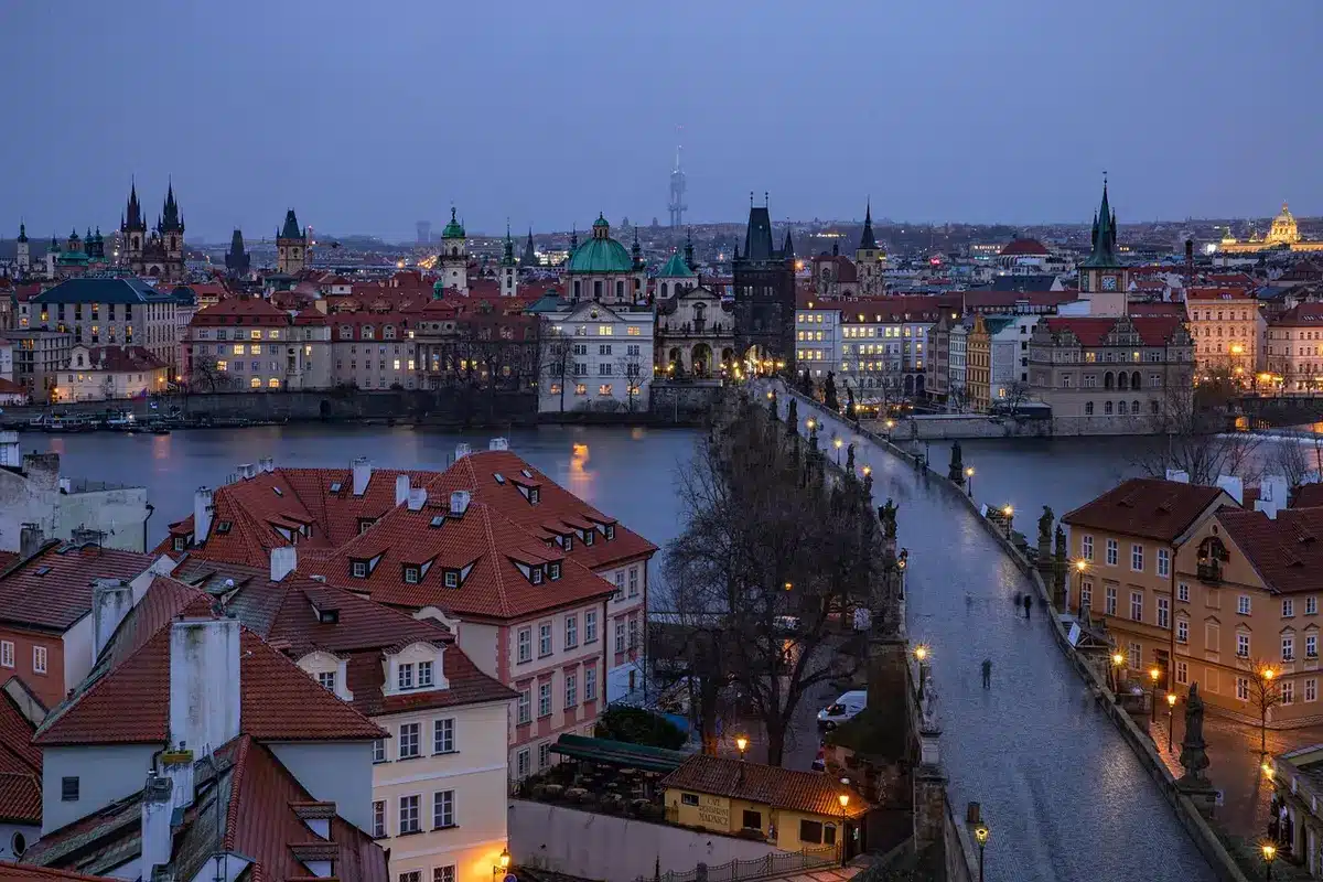 Distant city rooftops and a courthouse exterior at dusk with anonymous silhouettes