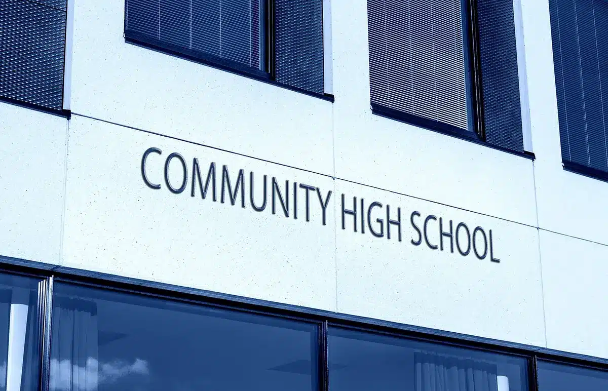 Exterior of a school building with a generic notice board about transition plans