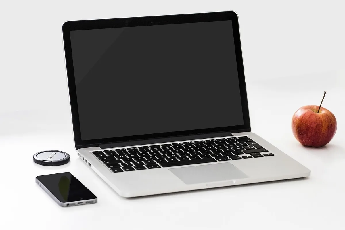 Newsroom desk with laptop, printed transcript and smartphone showing audio waveform