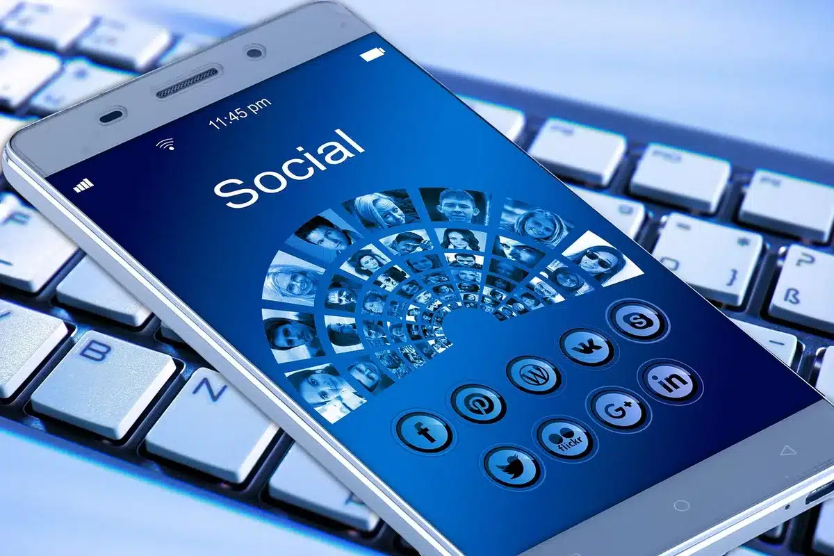 Close-up of hands holding a smartphone showing a social media post, representing contentious online rhetoric