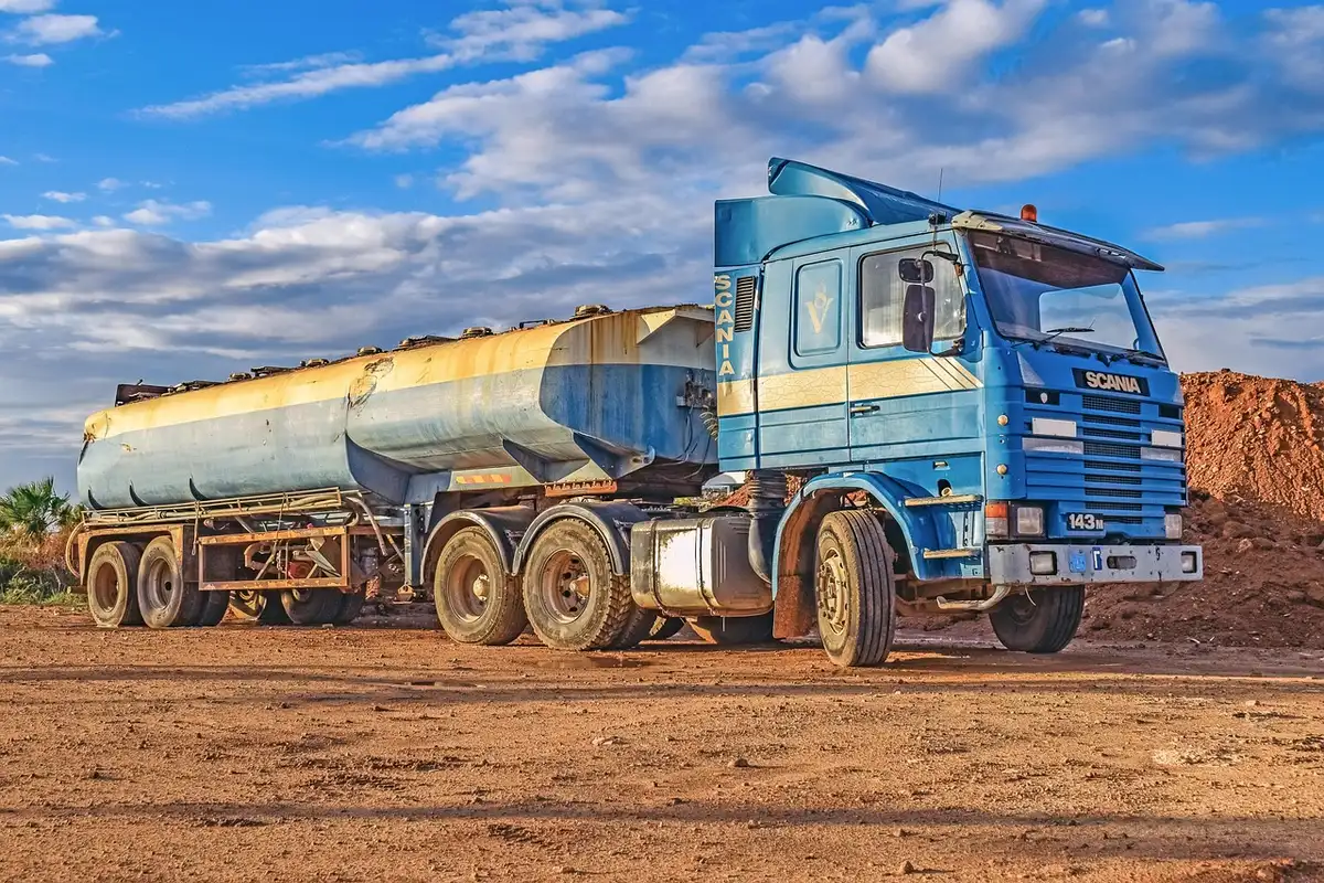 Industrial fertilizer storage tanks and delivery trucks at a plant