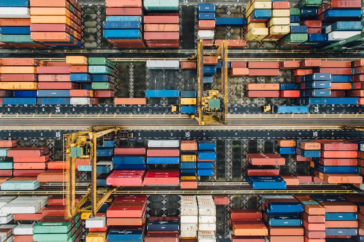 Busy shipping containers at a port illustrating rising trade and imbalances