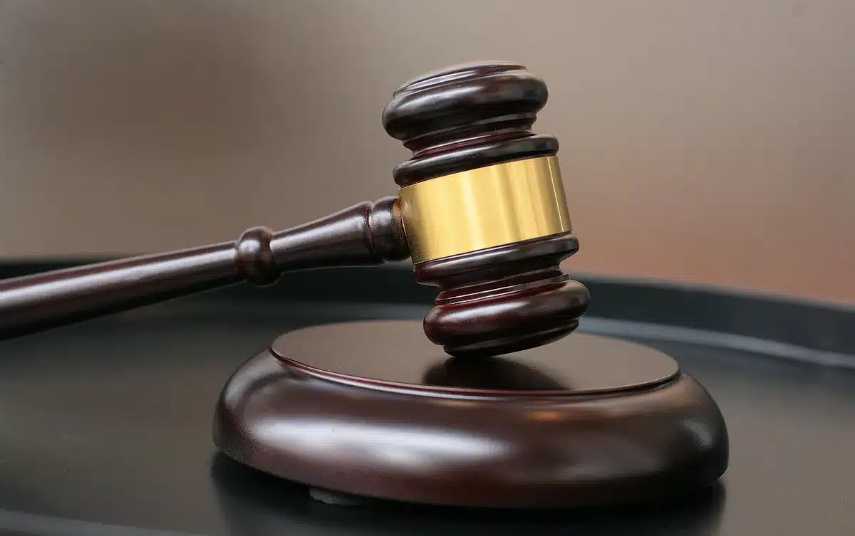Stack of legal documents and a gavel outside a courtroom