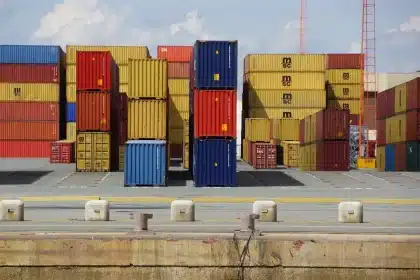 Port dock with stacked containers and a clipboard on a clipboard near a truck