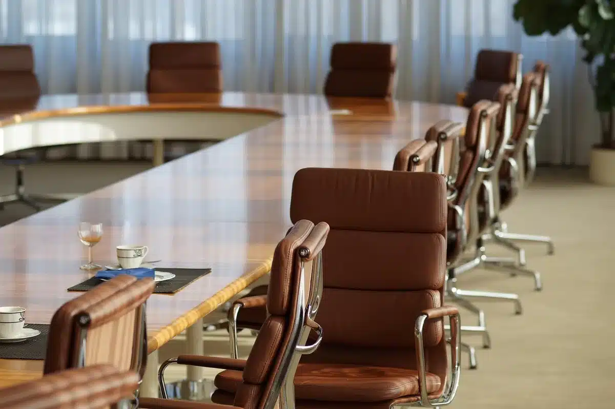 Boardroom meeting with documents labeled compliance (generic, no logos)