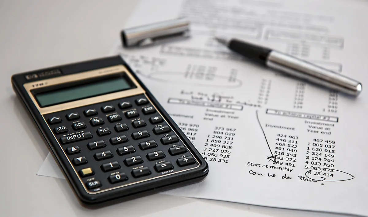 Stack of homeowners insurance documents with a damaged roof photo