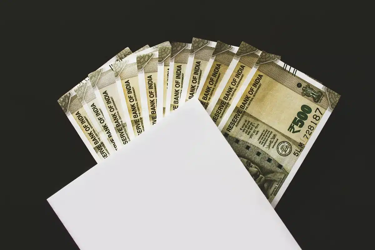 Stack of campaign fundraising envelopes and donation jars representing costly race