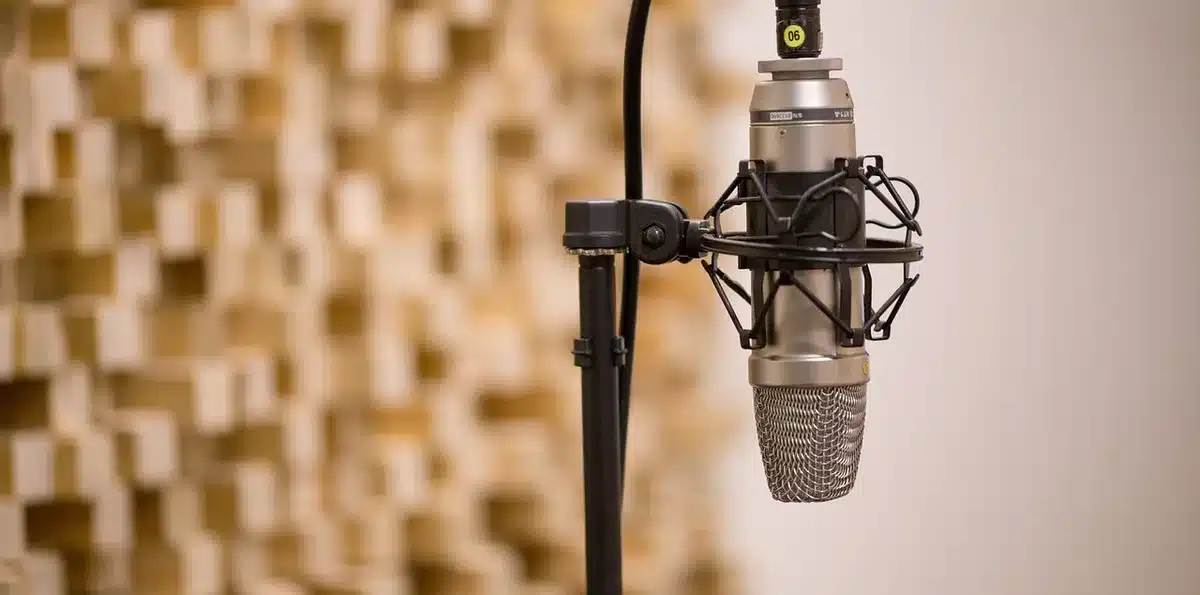 Studio microphone and papers on a radio host desk, no identifiable person
