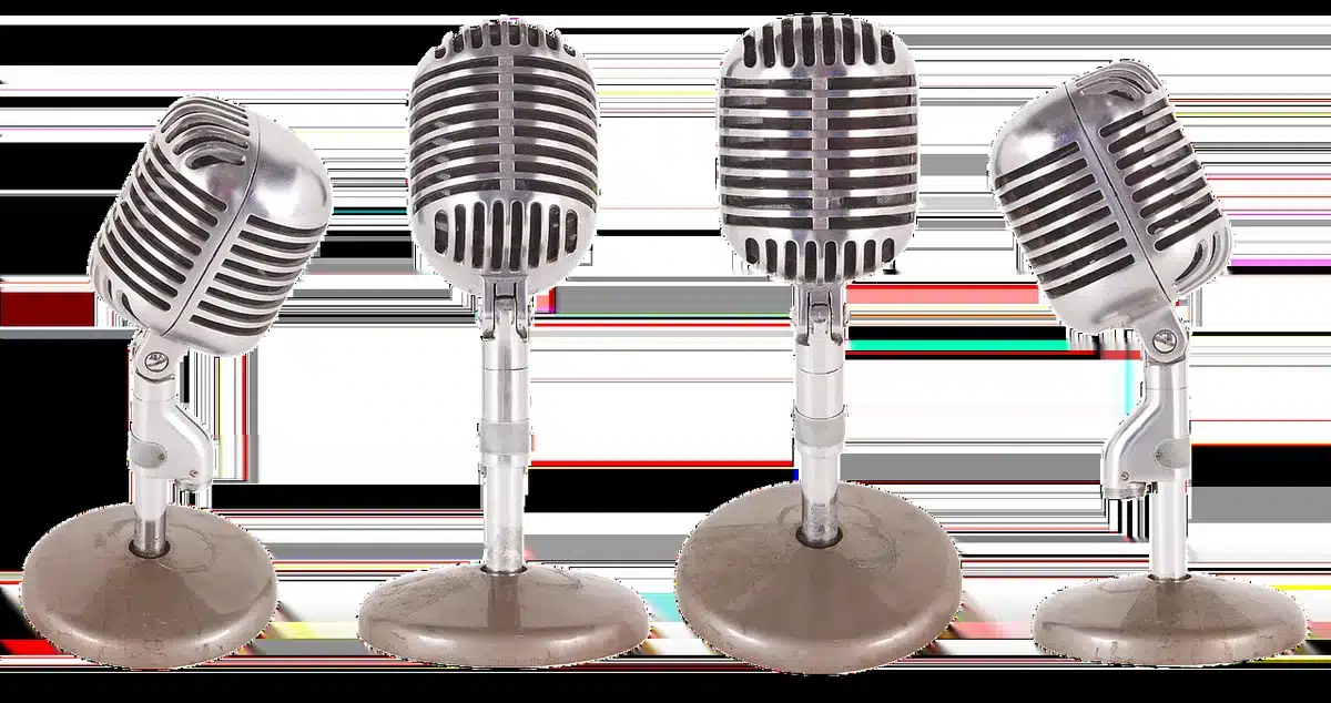 Two silhouettes in conversation beside a microphone in a studio