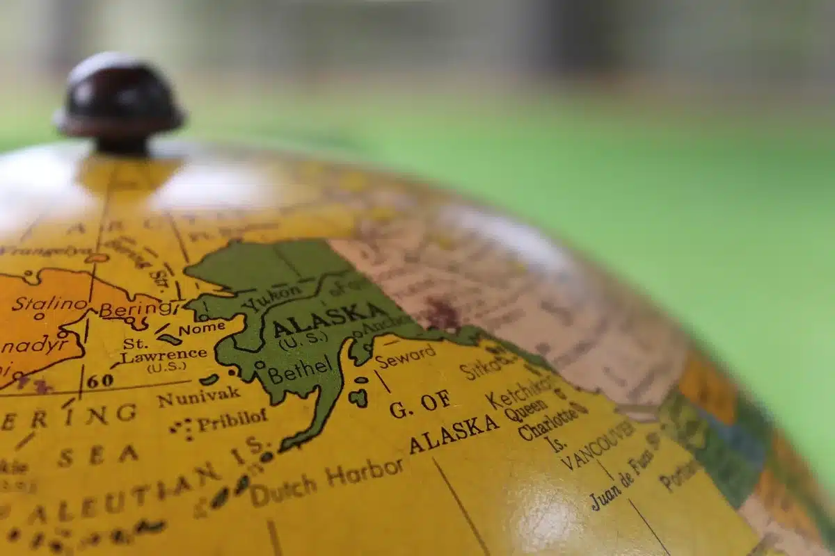 Two podiums silhouetted against a map backdrop representing a political debate in Alaska