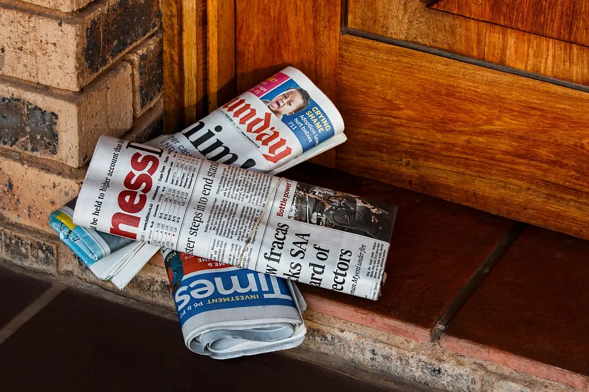 Folded newspapers with political headlines spread on a table