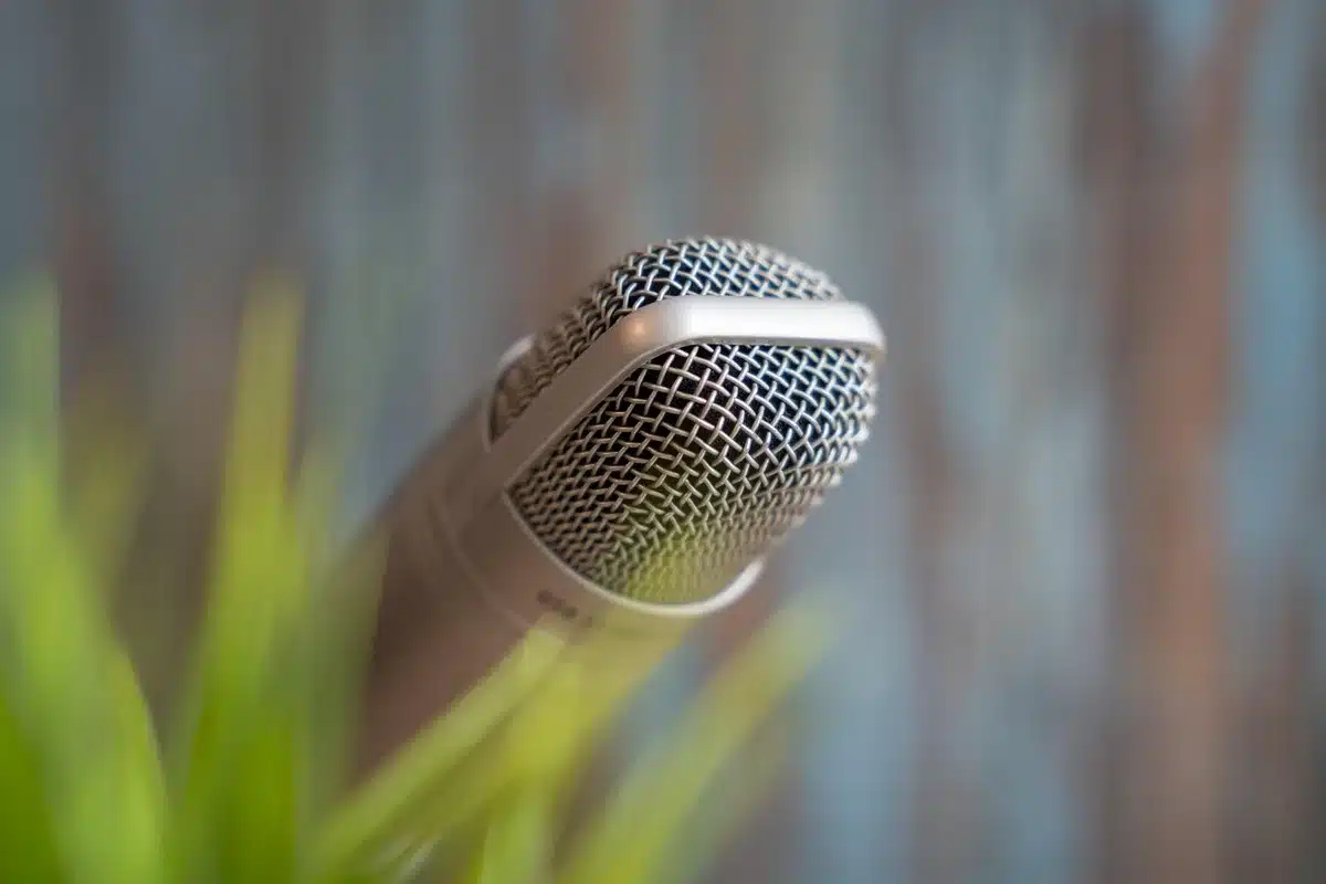Anonymous roundtable podcast hosts around a table with microphones in a bright studio