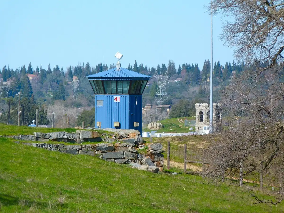 Security patrol near a perimeter fence and wooded area