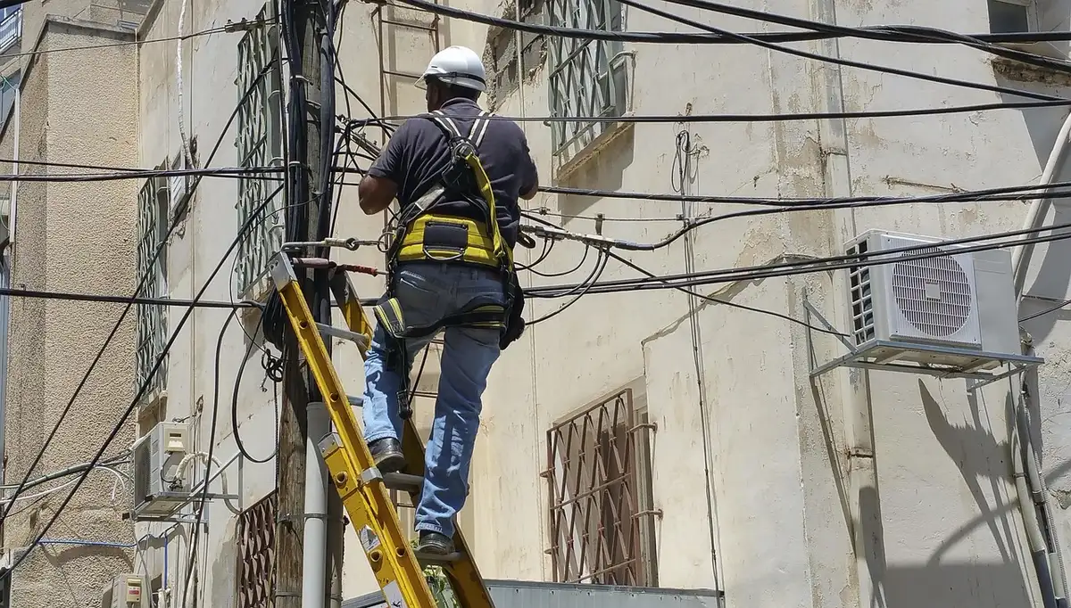 Workers near a beach with submarine cable equipment, no logos