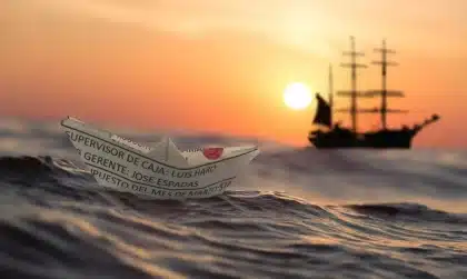 Anonymized coastal view of a shipping channel and a small vessel near a strait