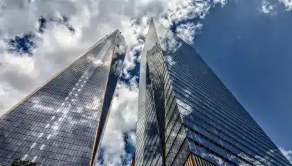 Anonymous office desk with payroll printouts and city skyline visible through a window
