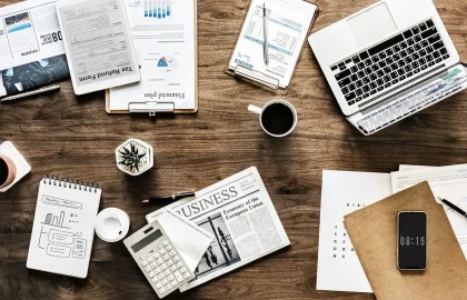 Hands typing on a laptop showing abstract blockchain visuals on a desk with a coffee cup