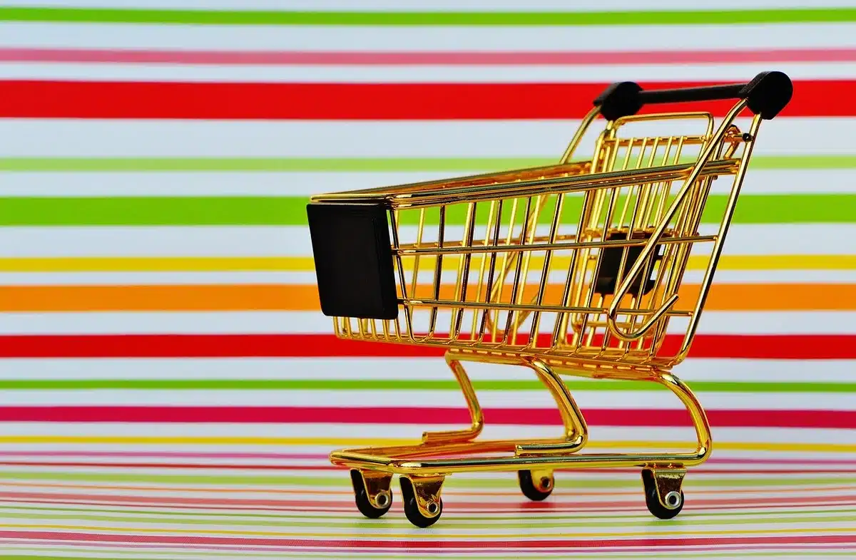 Customers pushing carts with bulk packs and prepared platters in a warehouse club